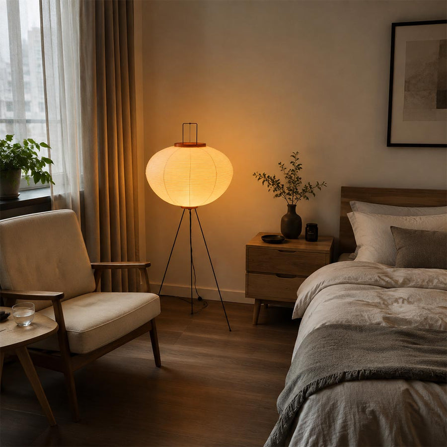 Cozy bedroom with a warm glowing washi paper tripod floor lamp placed beside the bed