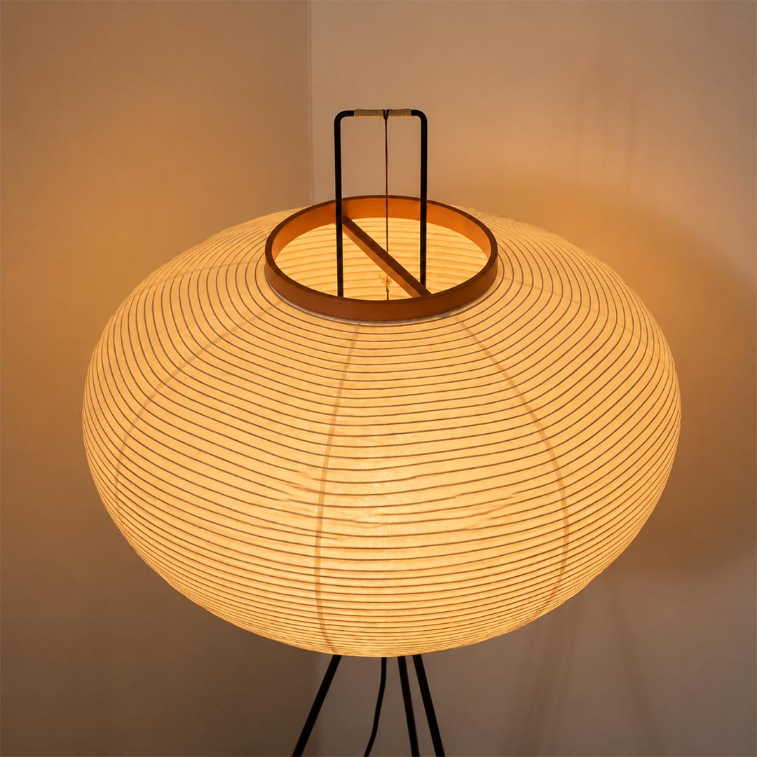 Detail shot of the top handle and orange wooden collar of the washi paper tripod floor lamp