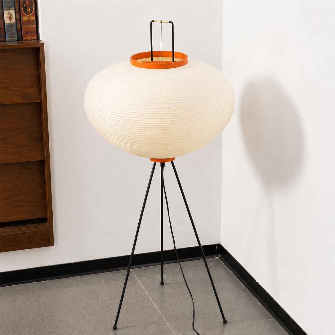 Japanese style washi paper tripod floor lamp with black tripod legs illuminated on white background