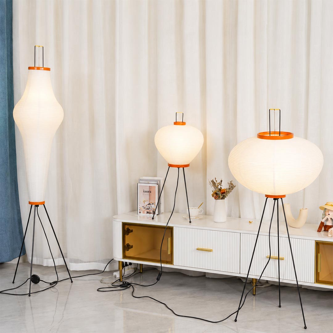 apanese style washi paper tripod floor lamp with black tripod legs illuminated on white background