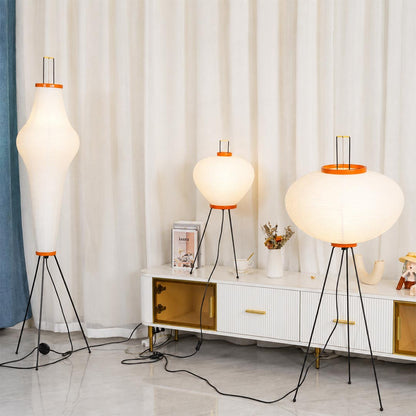 apanese style washi paper tripod floor lamp with black tripod legs illuminated on white background
