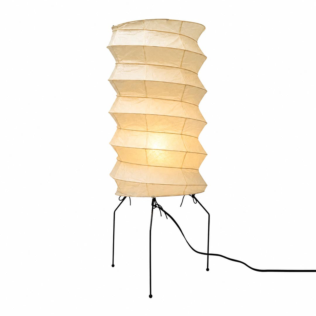Studio portrait of the illuminated ribbed cylinder Washi Paper UF2-31N Table Lamp with metal wire legs against white backdrop by Stuber Lighting.