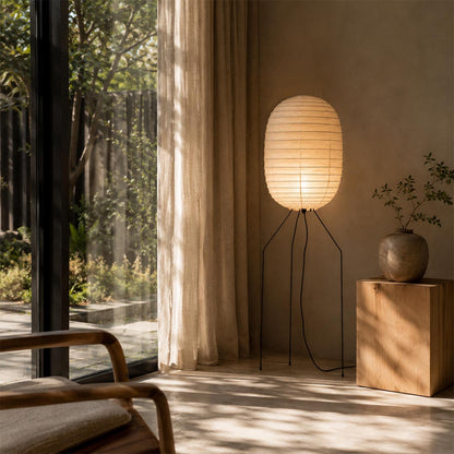 Washi Paper UF3-DL Floor Lamp placed by a massive glass door overlooking a scenic green forest view by Stuber Lighting.
