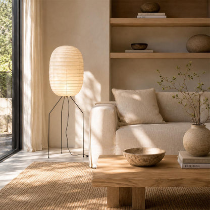 Soft ambient glow from a Washi Paper UF3-DL Floor Lamp next to a neutral fabric sofa in an organic modern home by Stuber Lighting.