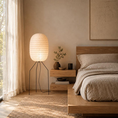 Elegant Japanese style Washi Paper UF3-DL Floor Lamp standing by a wooden platform bed as a warm bedside light by Stuber Lighting.