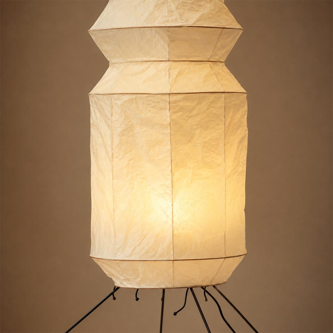Close-up detail of the warmly illuminated crumpled paper shade of a Washi Paper UF3-L6 Floor Lamp by Stuber Lighting.