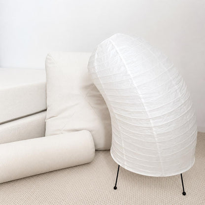 Aesthetic Washi Paper VB-13T Horn Lamp placed among white cushions and plush mattresses in a minimalist studio by Stuber Lighting.
