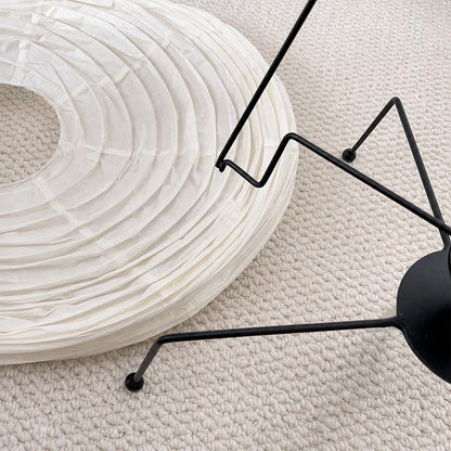 Flat-packed foldable paper shade and black metal wire components of the Washi Paper VB-13T Lamp by Stuber Lighting.