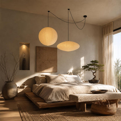Sculptural Washi Paper Whimsy Pendant Light adding a relaxing ambient glow over a wooden platform bed in a bedroom by Stuber Lighting.