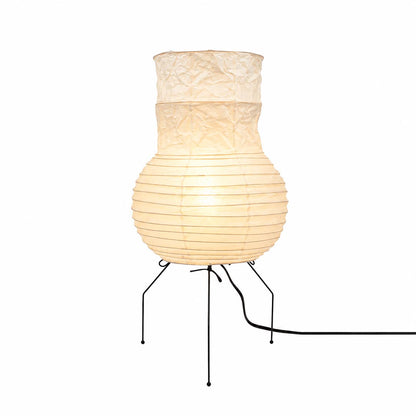 Warmly glowing vase-shaped Washi Paper Zara Table Lamp with a tripod wire base against a white background by Stuber Lighting.