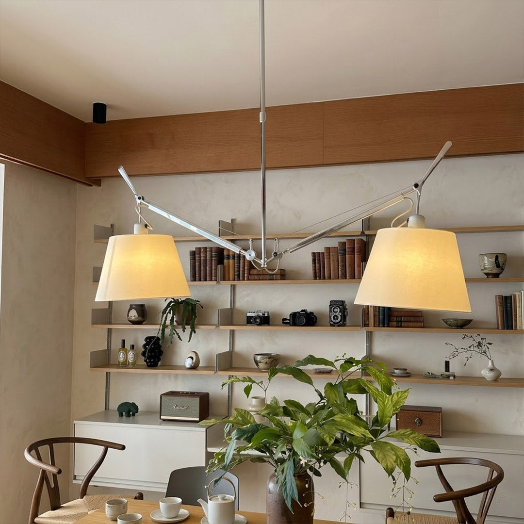 Wren swing arm pendant illuminating reading corner armchair warm parchment glow library at dusk cozy interior