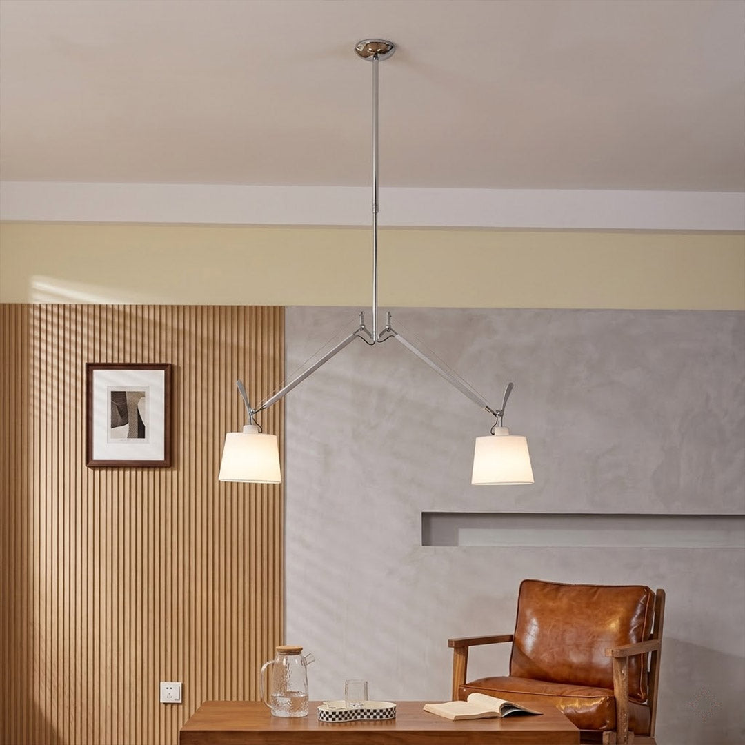 Wren swing arm pendant illuminating reading corner armchair warm parchment glow library at dusk cozy interior