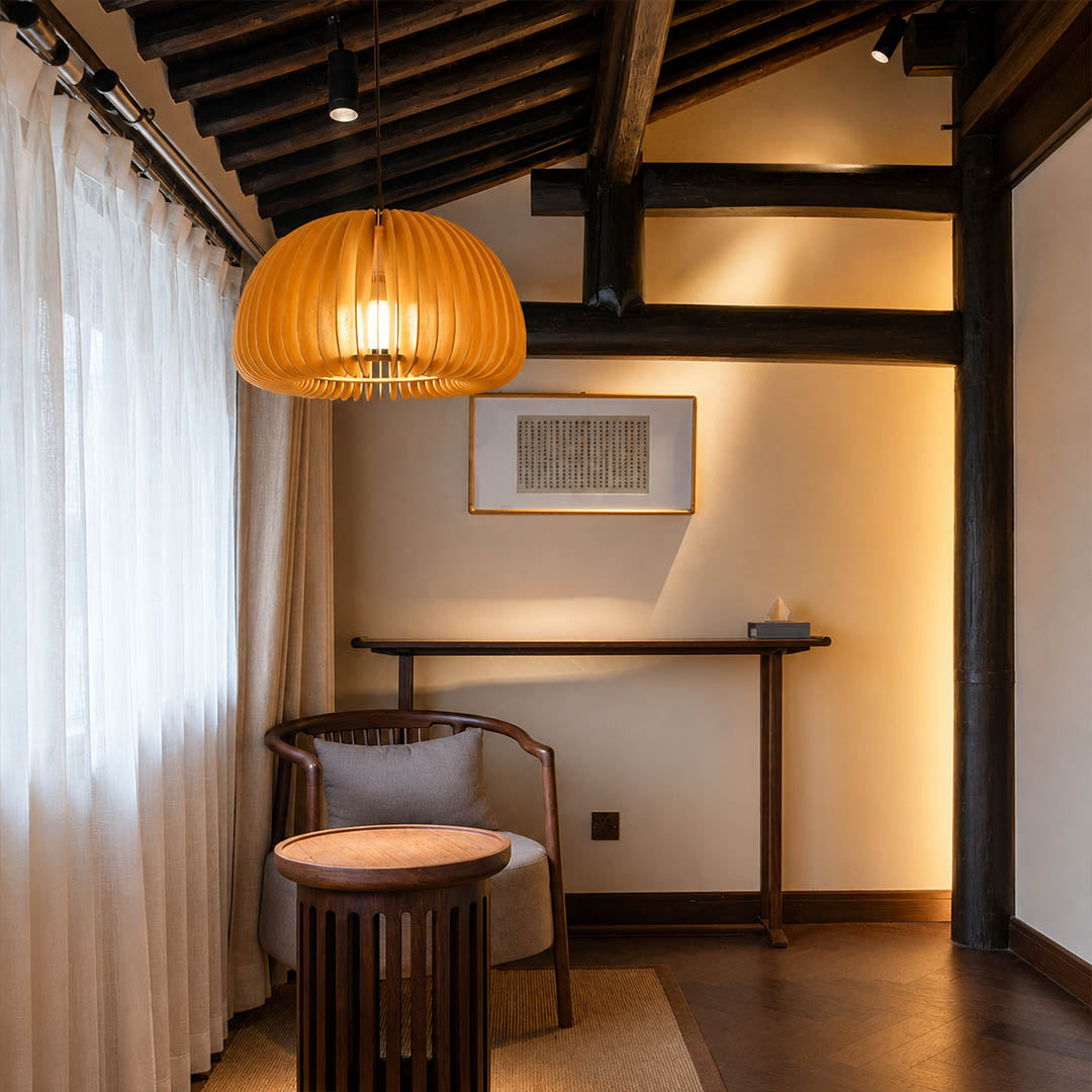 Zucca wood slat pendant light illuminated warm glowing evening room natural wood slats atmospheric shadow pattern cozy American home lifestyle interior